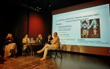 Pięciu panelistów na scenie obok ekranu z prezentacją.