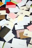 Rozrzucone koperty w różnych kolorach i wzorach na stole.