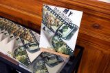 Stosy katalogów „My mosinianie – przeszłość i teraźniejszość” leżą na stoliku, jeden egzemplarz stoi na sztaludze.