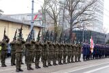 Żołnierze oddają salwę honorową z karabinów podczas oficjalnej ceremonii.