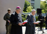 Duchowni stojący przy pomniku i czytający modlitwę