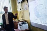 Mężczyzna prezentujący mapę na ekranie w sali wykładowej.