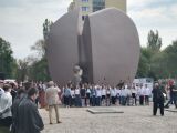 Ceremonia przy pomniku z grupą młodzieży śpiewającej.