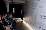 Wystawa z tekstem, uczestnicy słuchają prelekcji.